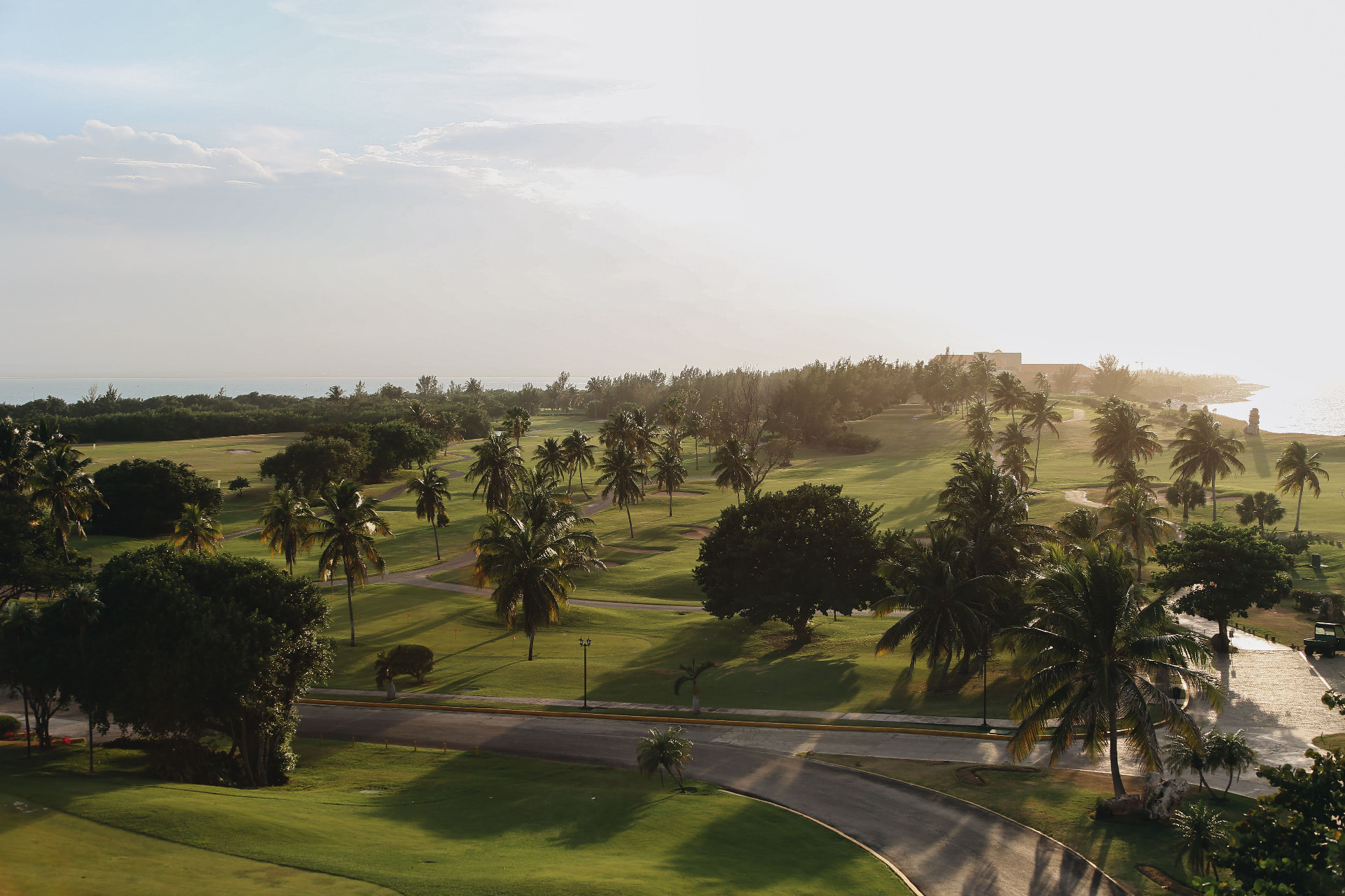 International golf travel demand: coastal destination golf resort course with palm-lined fairways at sunrise