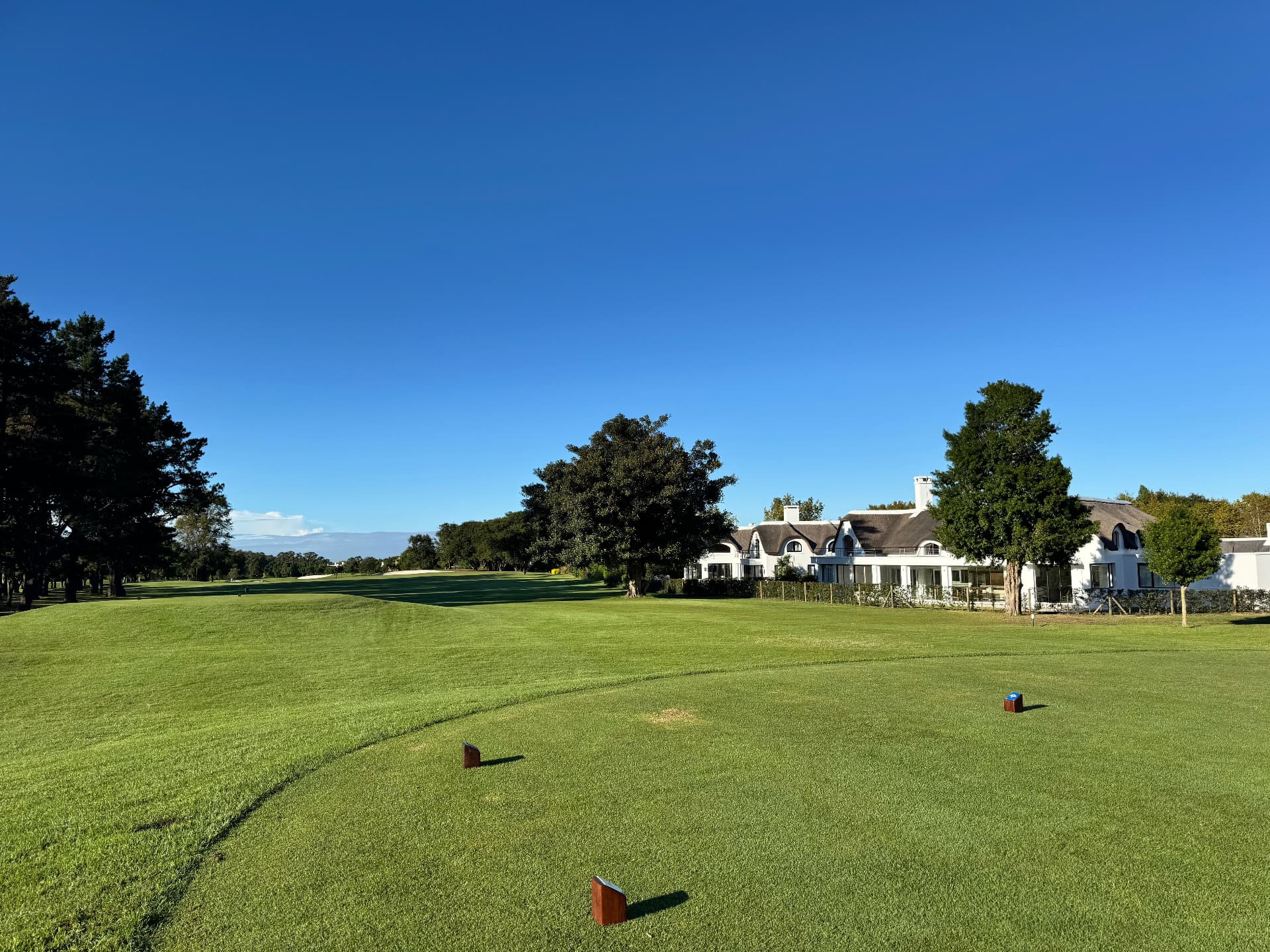 Golf resort experience marketing: clubhouse and resort hotel overlooking the 18th fairway